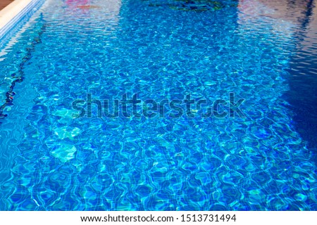 Transparent clear water in the pool. blue mosaic tiles, water texture.