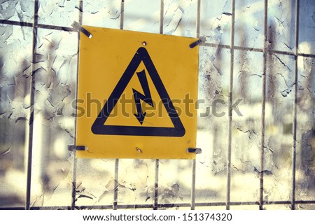 Electricity sign hanging on the fence