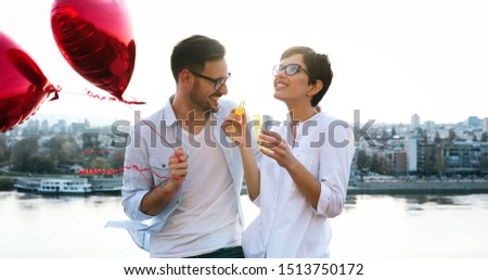 smiling couple in love with balloons on sunset