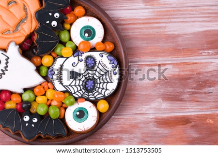 Halloween party decoration concept. Halloween gingerbread cookies on a wood background.