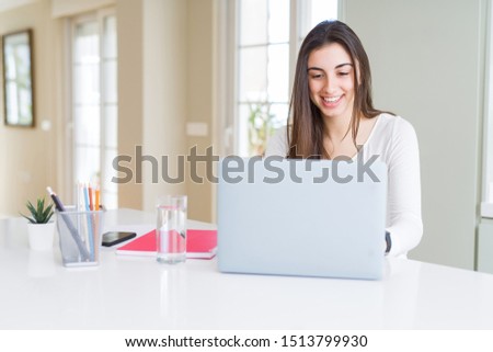 Young beautiful woman smiling happy and working using computer laptop