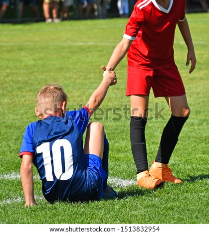 Young kid soccer player helps on the field Royalty-Free Stock Photo #1513832954