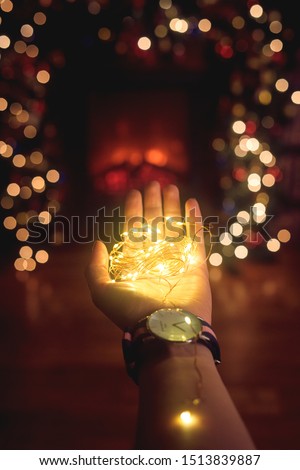 hand with a Christmas garland in the palm clok