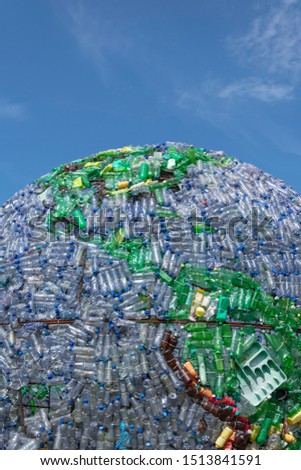 part of the globe made of plastic bottles and other plastic waste as a background dark blue sky. pictures taken vertically