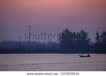 Lone fisherman fishing on Thu Bon river at dawn, Hoi An, Vietnam. Hoi An is recognized as a World Heritage Site by UNESCO.