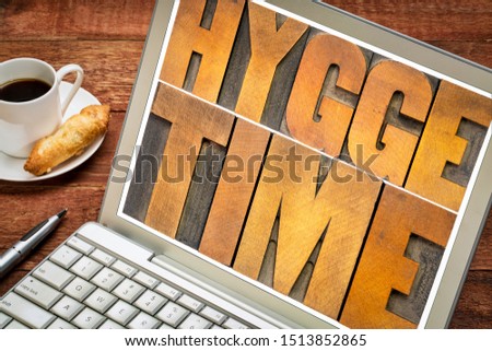 hygge time  word abstract in vintage letterpress wood type blocks on a laptop screen, Danish lifestyle concept