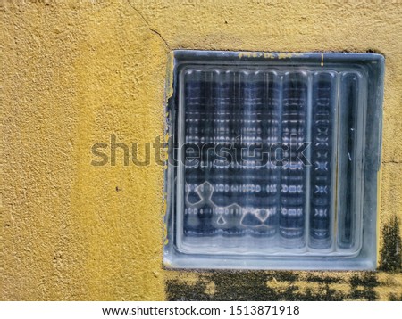 Glass block on old yellow wall