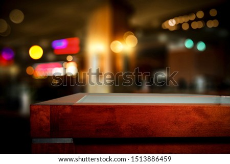 Wooden table of free space for your decoration and blurred bar background. 