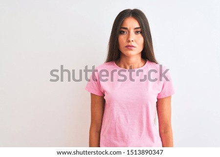 Young beautiful woman wearing pink casual t-shirt standing over isolated white background Relaxed with serious expression on face. Simple and natural looking at the camera.