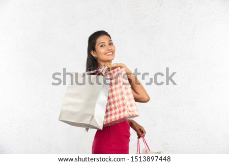 young indian woman having shopping bags and gifts, white background