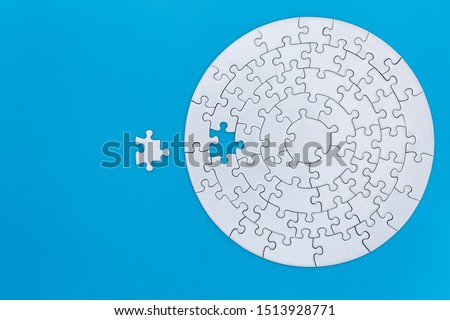 Unfinished white jigsaw puzzle pieces on blue background, The last jigsaw puzzle of success. Royalty-Free Stock Photo #1513928771