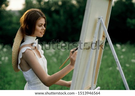 beautiful young woman draws on canvas