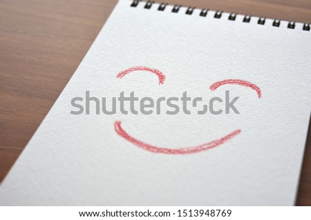 Illustration of smile in sketchbook on a board. In diagonal angle. Close up.