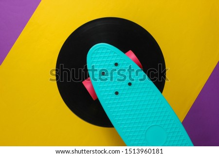 Cruiser board on vinyl record. Purple yellow background. Youth retro style concept. 80s. Top view
