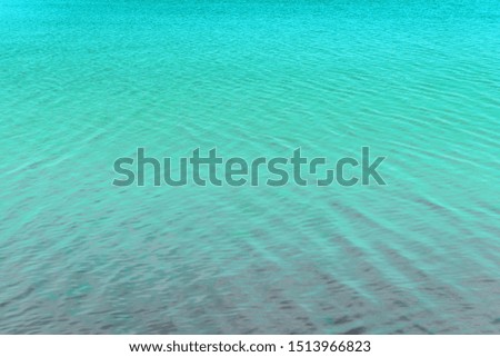 Blurred water background. Texture of small ripples on the water. Saturated blue shades with a light gradient.
