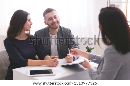 Mortgage consultation. Young family listening to financial advisor, ready to sign credit contract at office Royalty-Free Stock Photo #1513977326
