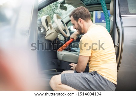Top cleaner. Man sucking car.