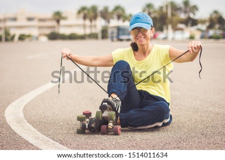 On the road, a smiling skater ties her skates