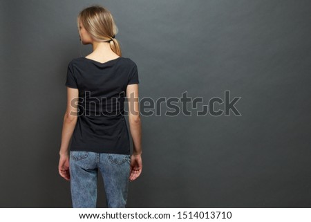  woman or girl wearing black blank t-shirt with space for your logo, mock up or design in casual urban style over gray background