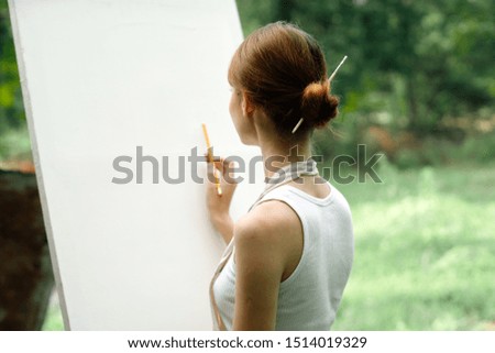 woman easel paints paints a picture