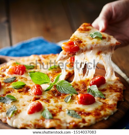 Pizza Margherita on black stone background, top view. Pizza Margarita with Tomatoes, Basil and Mozzarella Cheese close up. Royalty-Free Stock Photo #1514037083