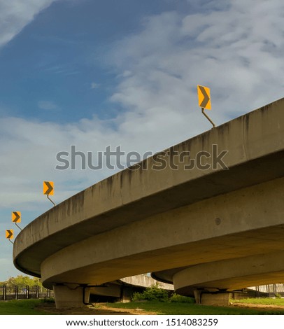 The arrows traffic signal is installed on the curve of the bridge and the background is a blue sky and white cloud