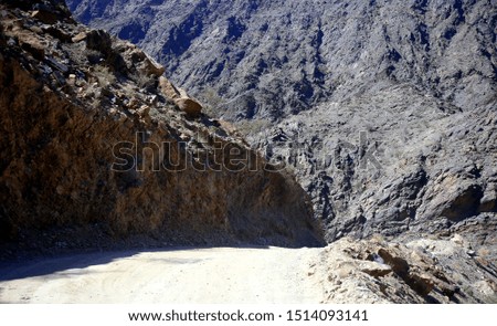 The narrow rocky trail between the high arid rocky mountains of the Wadi Bani Awf, Al Rustaq, South Batinah Governorate of Oman
