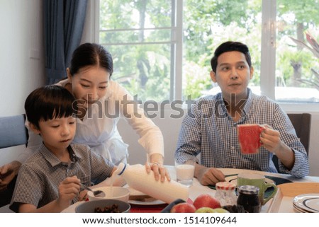Asian family, father and son having breakfast together with mother in dining room, happy family concept