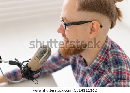 Radio, DJ, blogging and people concept - Close-up of smiling man sitting in front of microphone, host at radio
