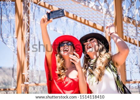 Two cheerful girls taking a picture with the phone