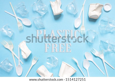 Set of plastic utensils glasses, forks, spoons on a blue background, flat lay. Concept collection of recycling plastic waste recycling. Ecology environmental care