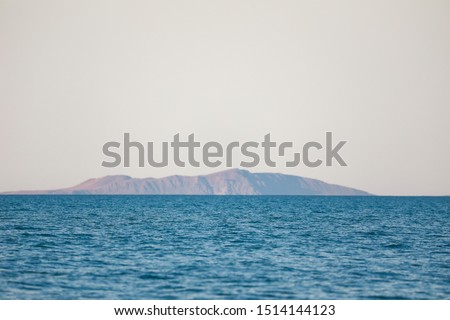Island in the sea "Alakol". Summer. Quiet weather. "Dzungarian" mountains. Kazakhstan, Almaty region.