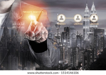 Business man with pointing to something or touching a touch screen overlay with cityscape. Double Exposure. Business and Technology Concept