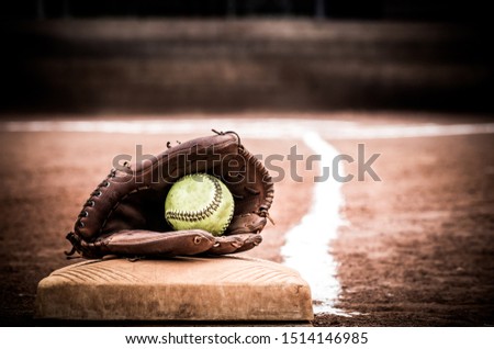 Softball glove with ball in it on base