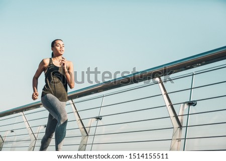 Determined young athlete in sporty clothes jogging on the bridge. Template banner