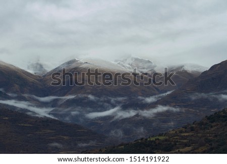 Snowy mountains in the Pyrenees among clouds.