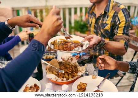 Group of diverse friends having dinner al fresco in urban setting Royalty-Free Stock Photo #1514193218