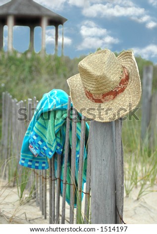 Beach hat on fence with towel