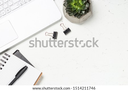 Office desk with laptop, notepad, succulent and pen on white background. Flat lay image with copy space