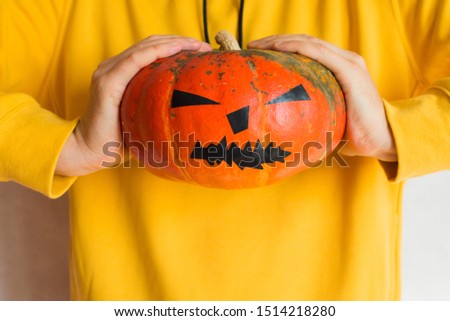 Halloween pumpkin. Man holding in hand a scary face pumpkin. Happy Halloween party holiday. Celebrate annual in October 31. Autumn season. Fall color, orange and yellow. Trick or treat. Pumpkin Day