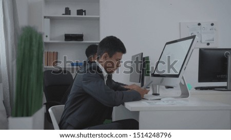 Two men sit at a table at the office.