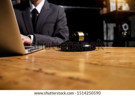 Justice and law concept. Lawyer businessman working on laptop at wood table office.