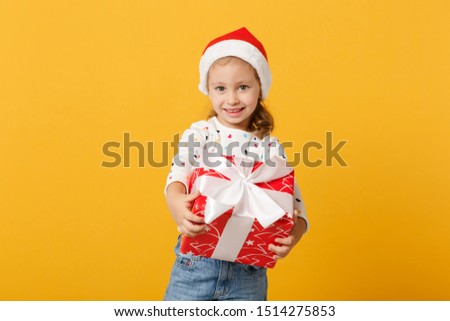 Child kid baby girl 4-5 years old wearing Christmas Santa hat isolated on pastel yellow wall background, children studio portrait. Happy New Year 2020 celebration holiday concept. Mock up copy space