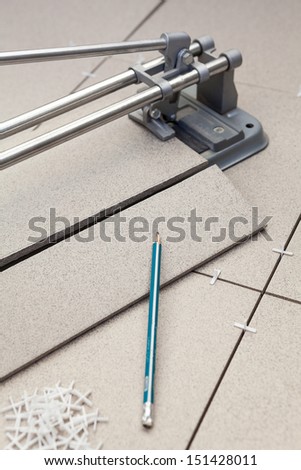 Cutting tiles with tile-cutter when laying floor