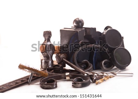 Metal vise, hammer, drill, ornamental iron, welding glasses on a white background