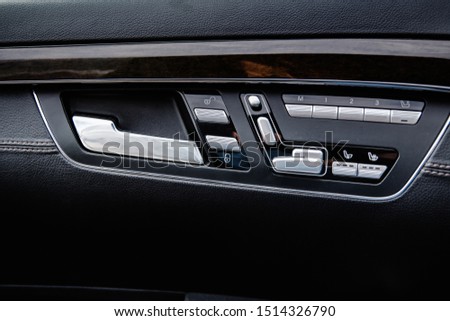 opening handle and control mechanisms on the door trim of a business class car with shallow depth of field