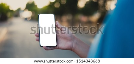 Mockup image of a man's hand holding black mobile phone with blank desktop screen