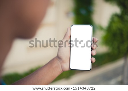 Mockup image of a man's hand holding black mobile phone with blank desktop screen
