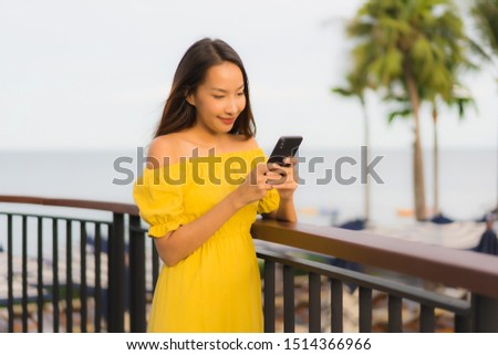 Beautiful portrait asian women using mobile or smart phone around sea beach ocean