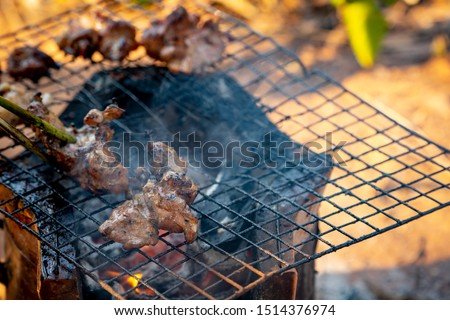 Blurred meat grilled cooking on stove in camping on hills 